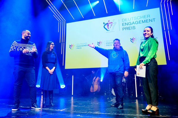 Zwei Engagierte von Über den Tellerrand auf der Bühne mit Sebastian Krumbiegel und Aline Abboud