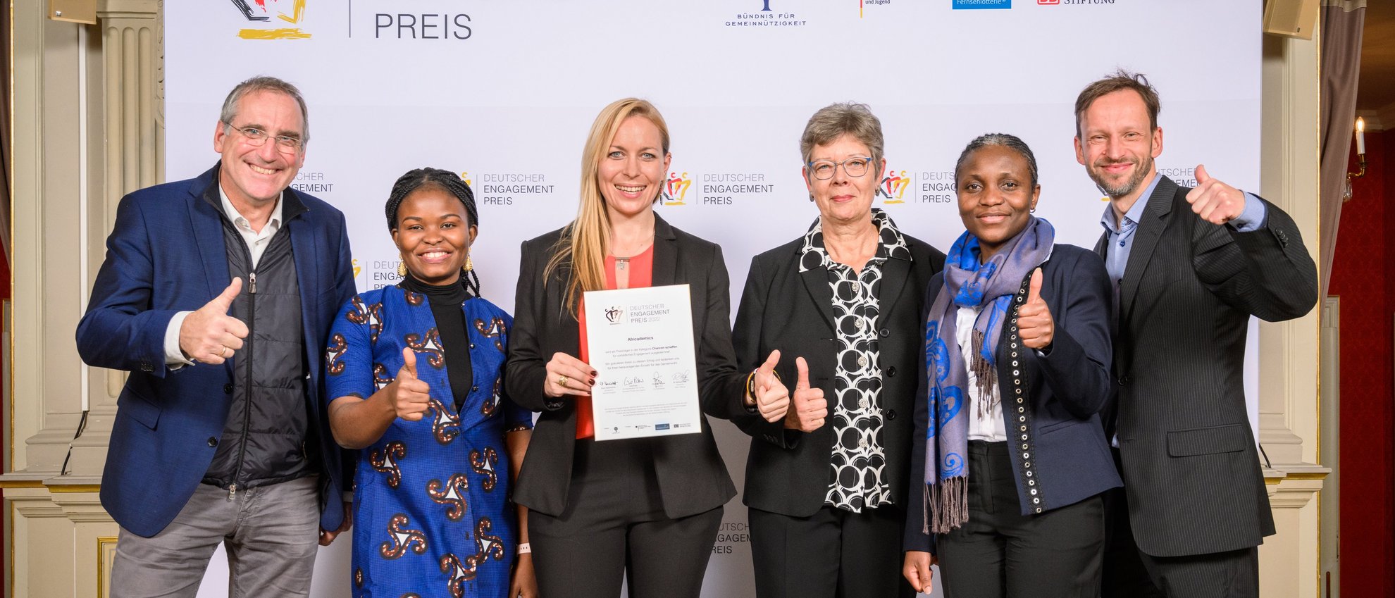 Engagierte von Africademics vor der Pressewand mit der Laudatorin Maiouma Ouattara und Jan Wenzel 