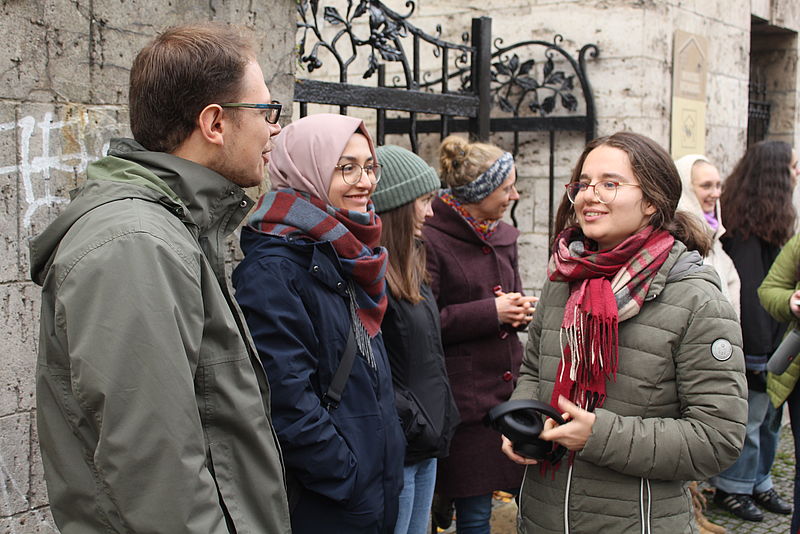 Drei junge Menschen in ein Gespräch vertieft