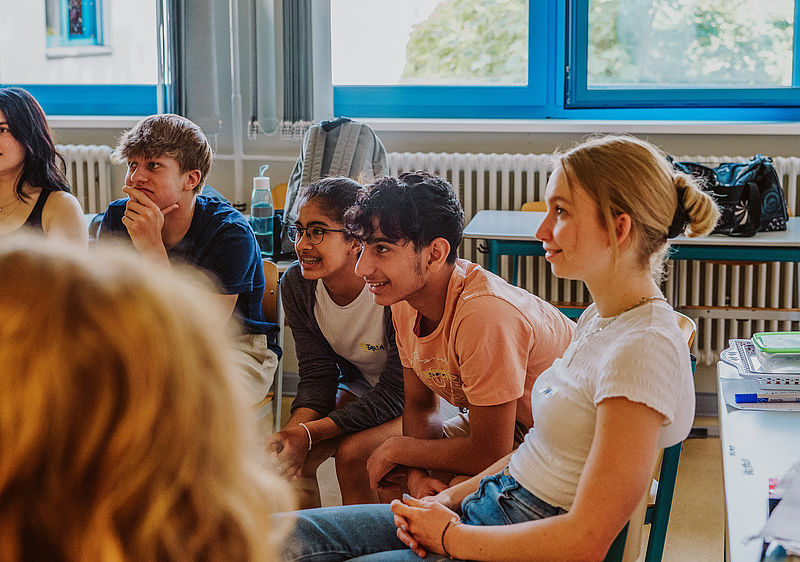 Junge Menschen hören gespannt bei einem Dare2Care Workshop zu