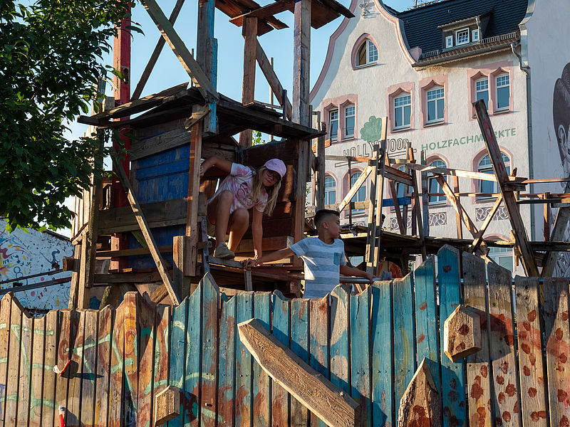 Kinder auf selbstgebauten Klettergerüsten