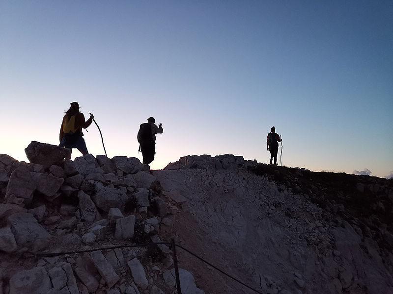 3 Teilnehmerinnen wandern auf dem Gipfel beim Sonnenaufgang