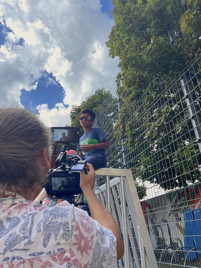 Samuel Ramm, wie er gerade einen der Jugendlichen bei seiner Performance auf dem Bolzplatz filmt.