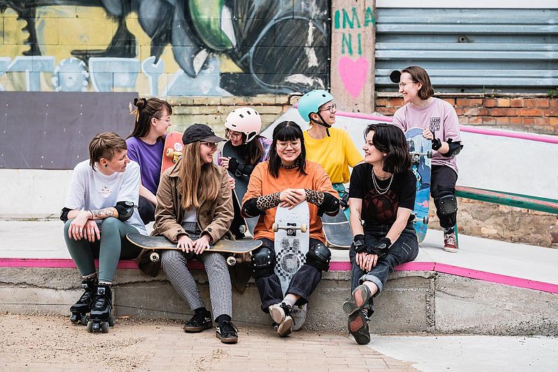 FLINTA*s sitzen gemeinsam im Skatepark