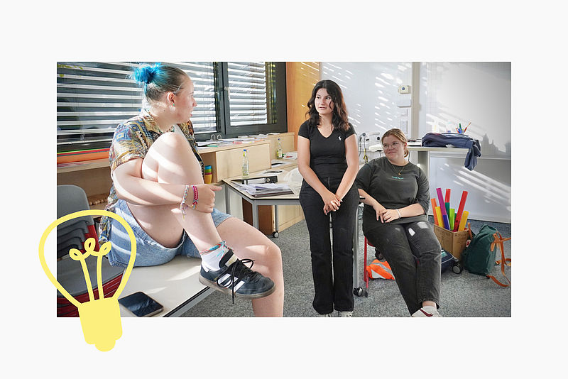 Eine Jugendliche scannt den QR-Code auf einer Werbewand. Darauf steht: Jeder sechste Jugendliche ist von Mobbing betroffen.