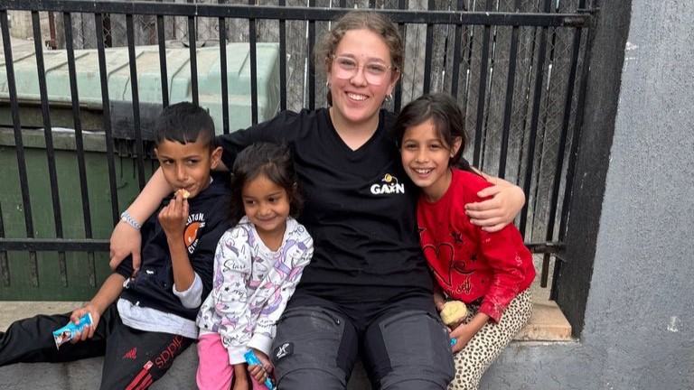 Teenager umgeben von drei Romakindern